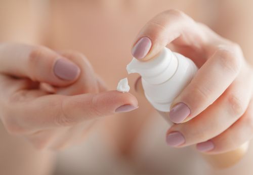 woman applying moisturizing cream to her finger tip